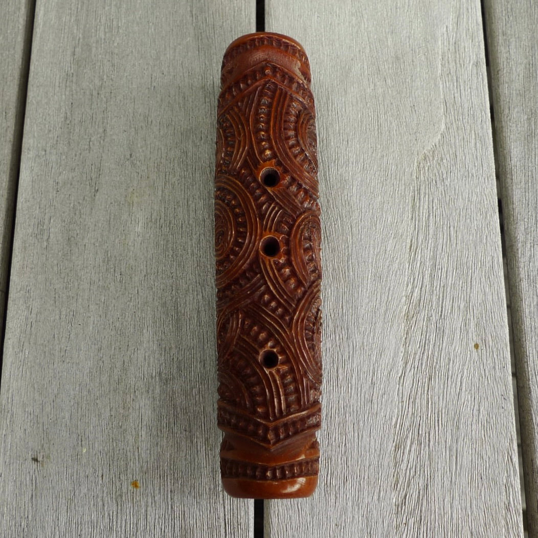 A traditional hand carved Māori flute. This piece is made from stained bone and is a fully functioning musical instrument and can be played. Beautiful ethnic art hand made by NZ Pacific. Hand carved by Yuri Terenyi.