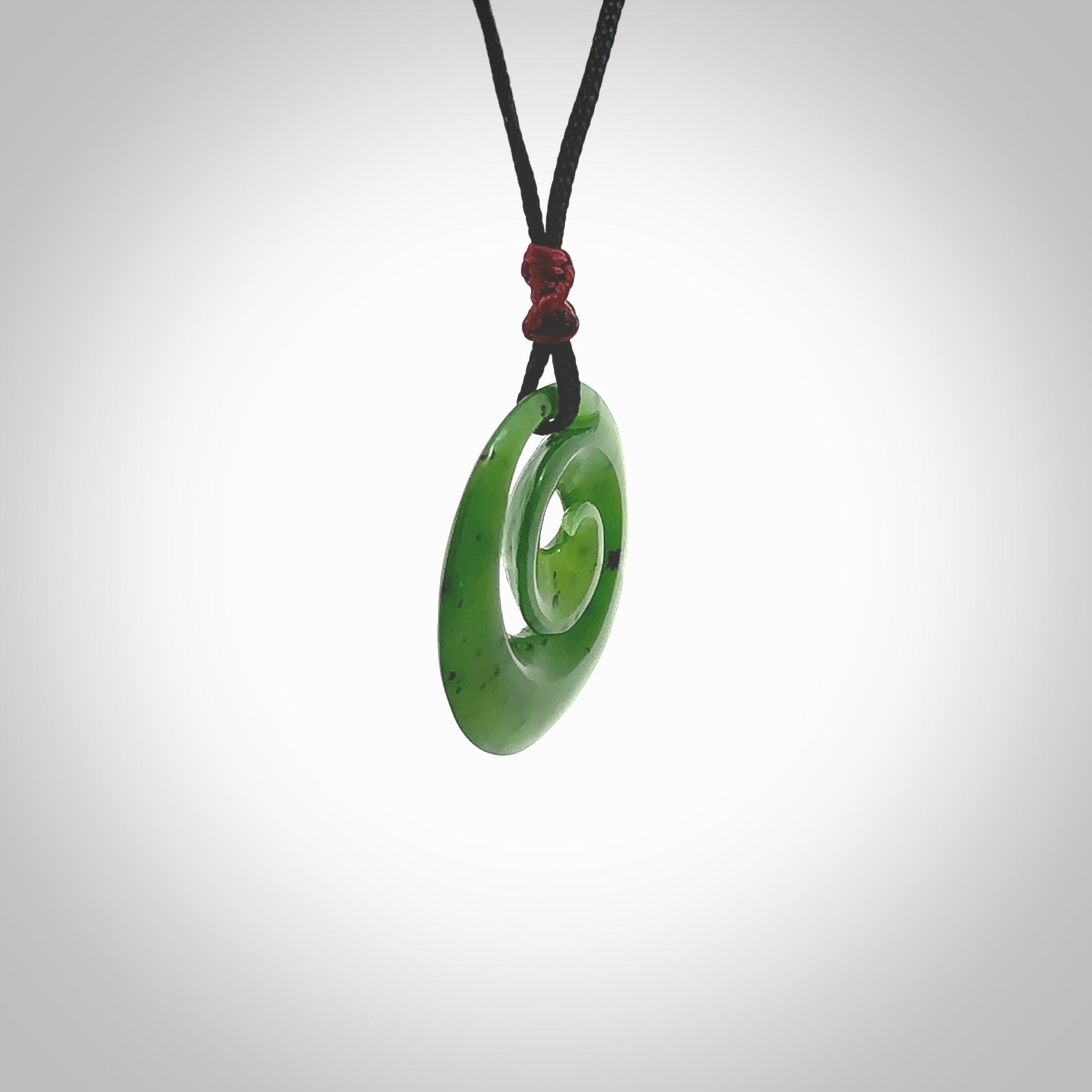 Hand carved New Zealand Kawakawa jade koru pendant. Carved for NZ Pacific by Ross Crump. Jade jewelry for sale online exclusively with NZ Pacific.