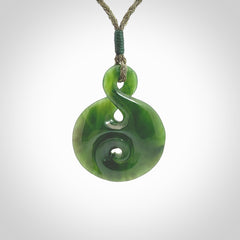 New Zealand Jade twist with koru pendant. Hand carved from rare New Zealand jade this is a beautiful pounamu pendant. The cord is hand plaited and is length adjustable. A very beautiful greenstone pendant. For sale online by NZ Pacific.