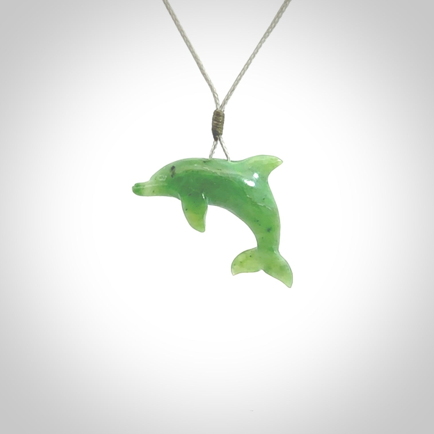 This is a gorgeous little dolphin pendant carved in green nephrite jade. The cord is a fine grey colour and is length adjustable so you can position the little jade dolphin where it suits you best. Shipping is free worldwide.