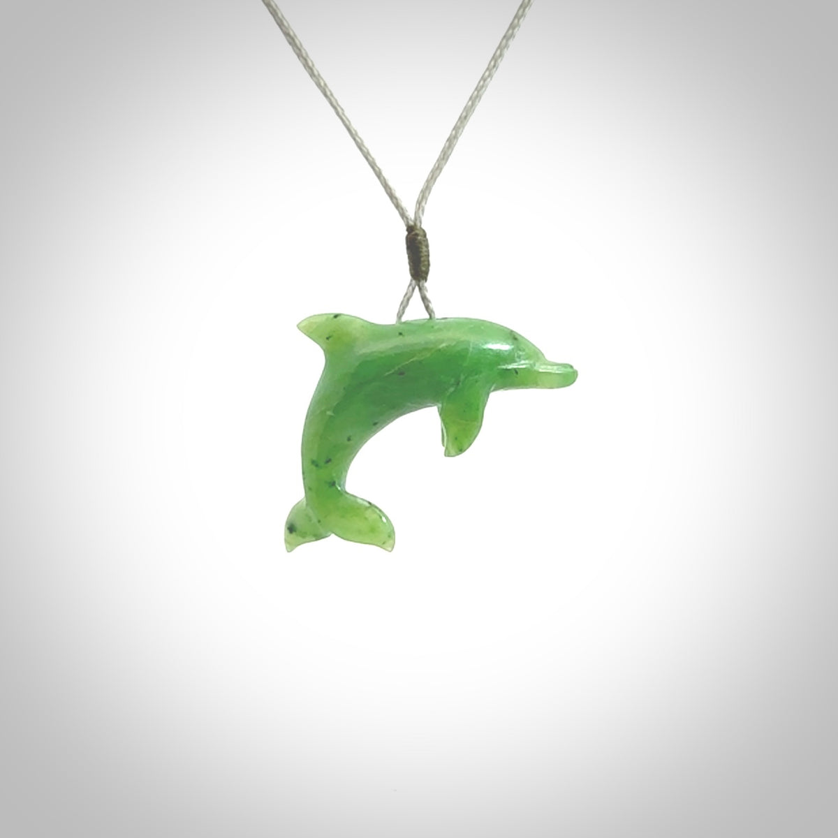 This is a gorgeous little dolphin pendant carved in green nephrite jade. The cord is a fine grey colour and is length adjustable so you can position the little jade dolphin where it suits you best. Shipping is free worldwide.