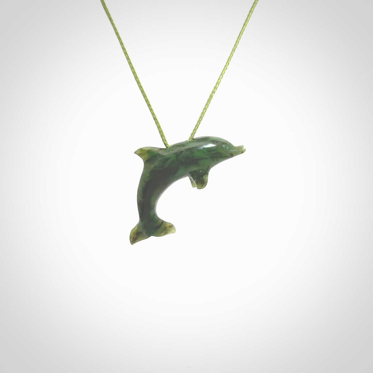 This is a gorgeous little dolphin pendant carved in green nephrite jade. The cord is a fine grass green colour and is length adjustable so you can position the little jade dolphin where it suits you best. Shipping is free worldwide.