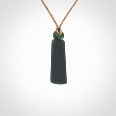 This pendant is a New Zealand jade single twist. It is hand carved from New Zealand Pounamu and has a mix of green, mint and pale colours interspersed throughout the stone. It has a fine twist, small and light. The cord is hand plaited and can be adjusted.