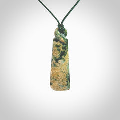 This pendant is a New Zealand jade single twist. It is hand carved from New Zealand Pounamu and has a mix of green, mint and pale colours interspersed throughout the stone. It has a fine twist, small and light. The cord is hand plaited and can be adjusted.