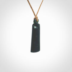 This pendant is a New Zealand jade single twist. It is hand carved from New Zealand Pounamu and has a mix of green, mint and pale colours interspersed throughout the stone. It has a fine twist, small and light. The cord is hand plaited and can be adjusted.