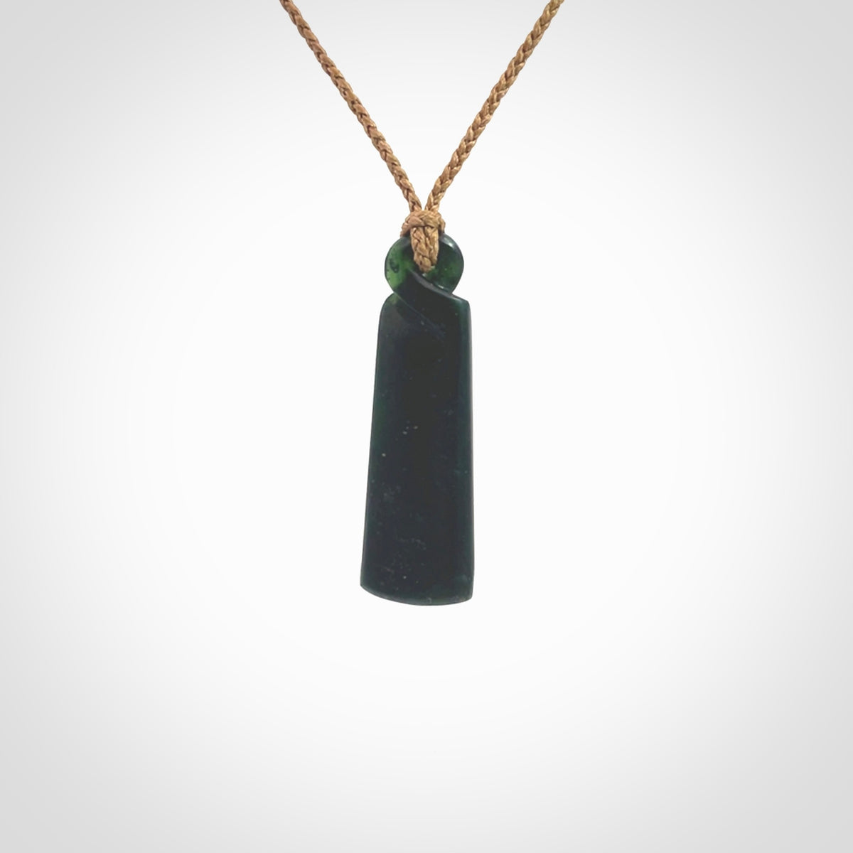 This pendant is a New Zealand jade single twist. It is hand carved from New Zealand Pounamu and has a mix of green, mint and pale colours interspersed throughout the stone. It has a fine twist, small and light. The cord is hand plaited and can be adjusted.