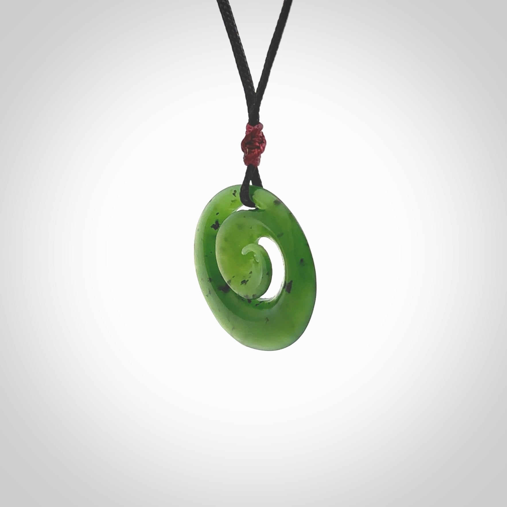 Hand carved New Zealand Kawakawa jade koru pendant. Carved for NZ Pacific by Ross Crump. Jade jewelry for sale online exclusively with NZ Pacific.