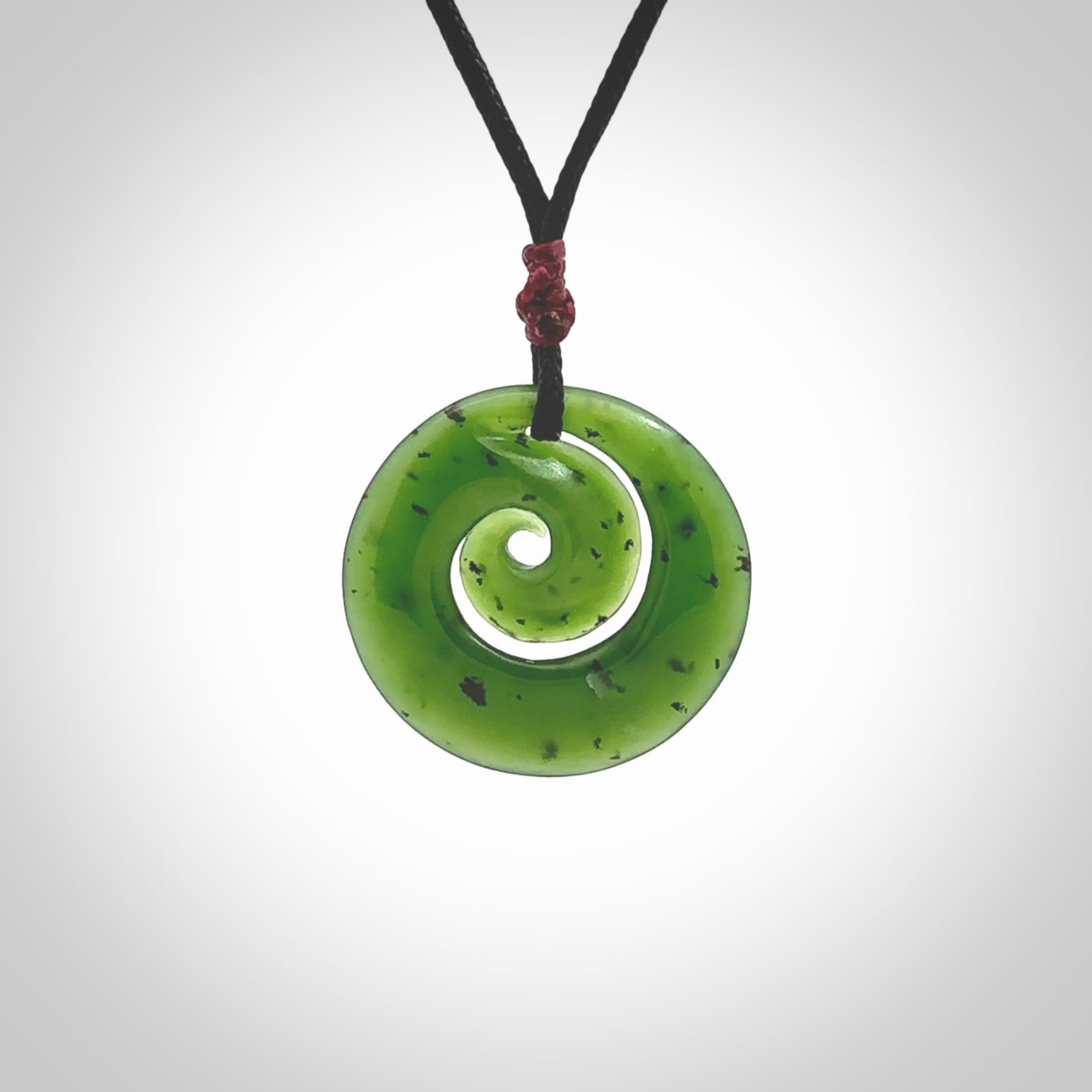 Hand carved New Zealand Kawakawa jade koru pendant. Carved for NZ Pacific by Ross Crump. Jade jewelry for sale online exclusively with NZ Pacific.