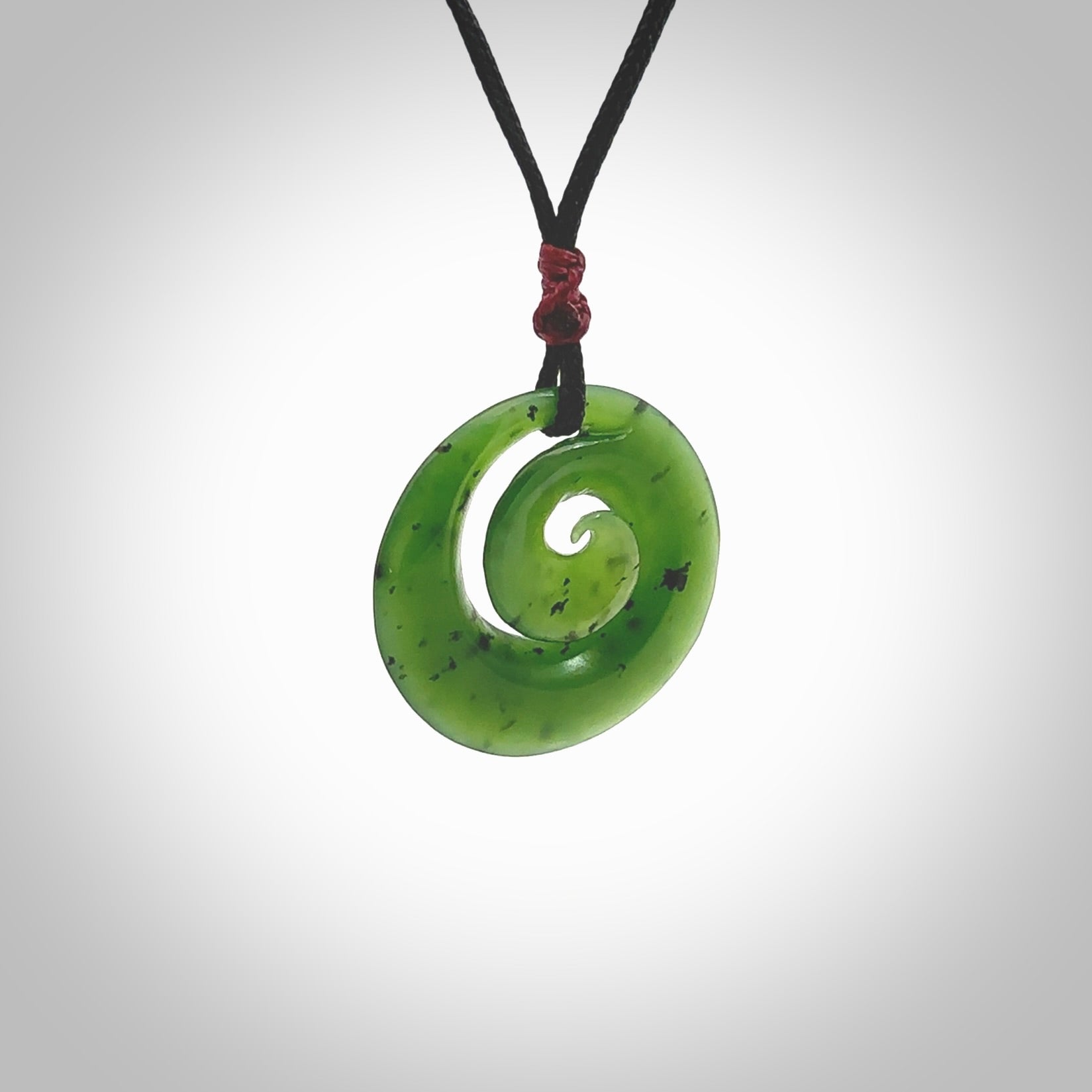 Hand carved New Zealand Kawakawa jade koru pendant. Carved for NZ Pacific by Ross Crump. Jade jewelry for sale online exclusively with NZ Pacific.