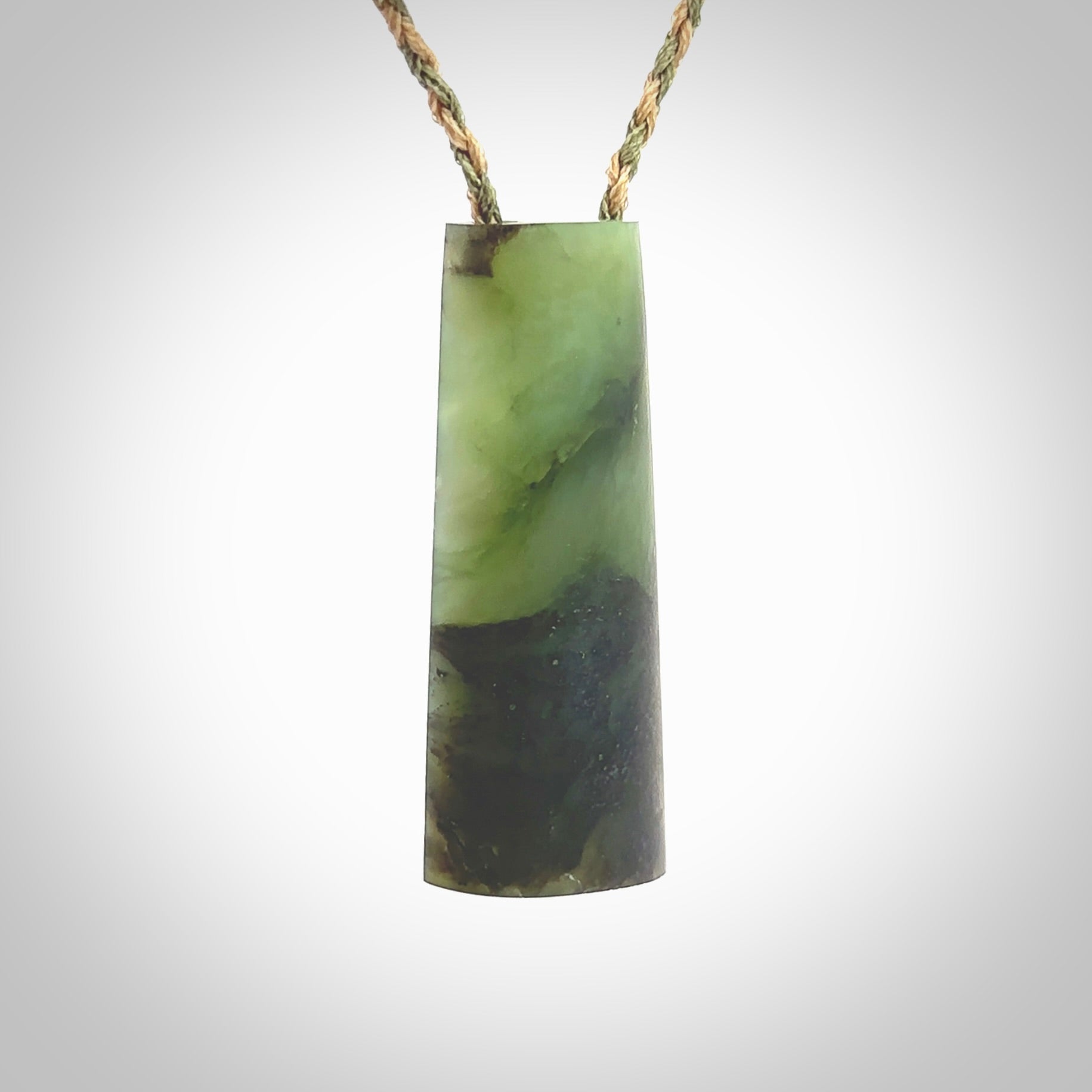 This photo shows a medium sized jade drop shaped pendant. It a a lovely, colourful douglas creek jade. The cord is a tan/green and is adjustable in length. One only large, contemporary drop necklace from Jade, by Rueben Tipene.