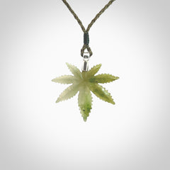 Cannabis Leaf Jade pendant with Sterling Silver Cap. Handmade jade Cannabis leaf jewellery made by NZ Pacific and for sale online. Jade Marijuana leaf pendant for men and women. Unique art to wear from NZ Pacific. Delivered on an adjustable Moss Green cord.