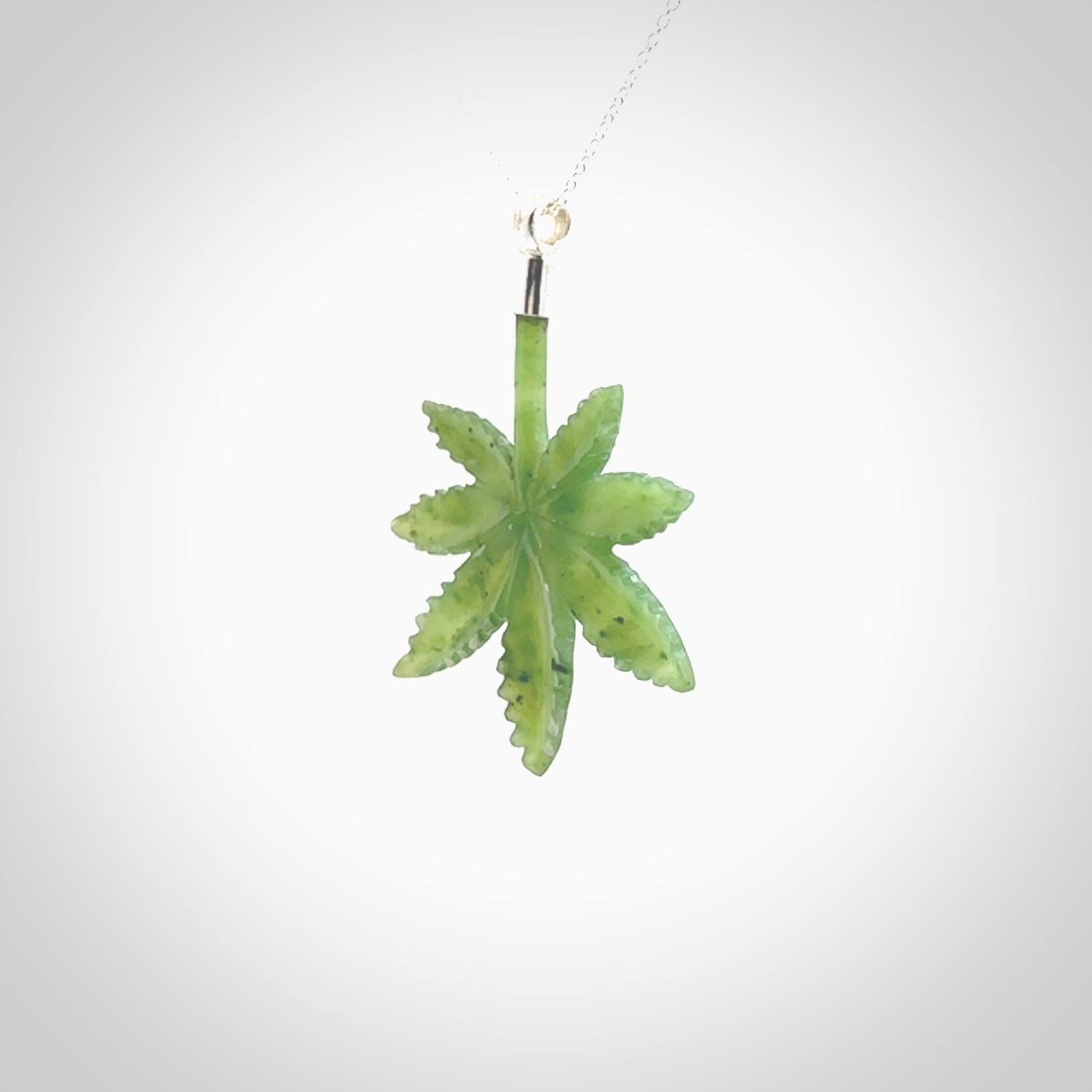 Cannabis Leaf Jade pendant with Sterling Silver Cap. Handmade jade Cannabis leaf jewellery made by NZ Pacific and for sale online. Jade Marijuana leaf pendant for men and women. Unique art to wear from NZ Pacific. Delivered on a Sterling Silver Chain.