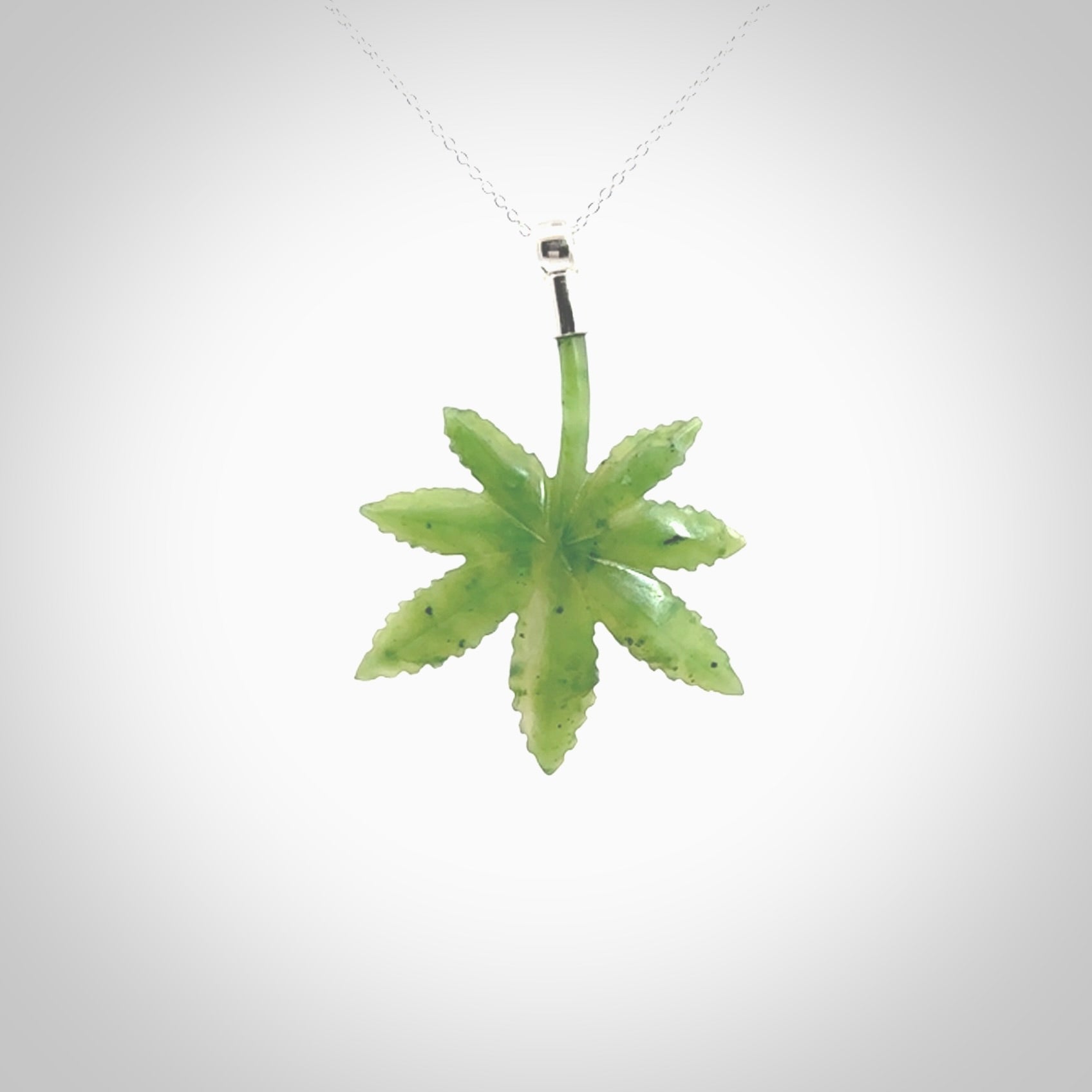 Cannabis Leaf Jade pendant with Sterling Silver Cap. Handmade jade Cannabis leaf jewellery made by NZ Pacific and for sale online. Jade Marijuana leaf pendant for men and women. Unique art to wear from NZ Pacific. Delivered on a Sterling Silver Chain.