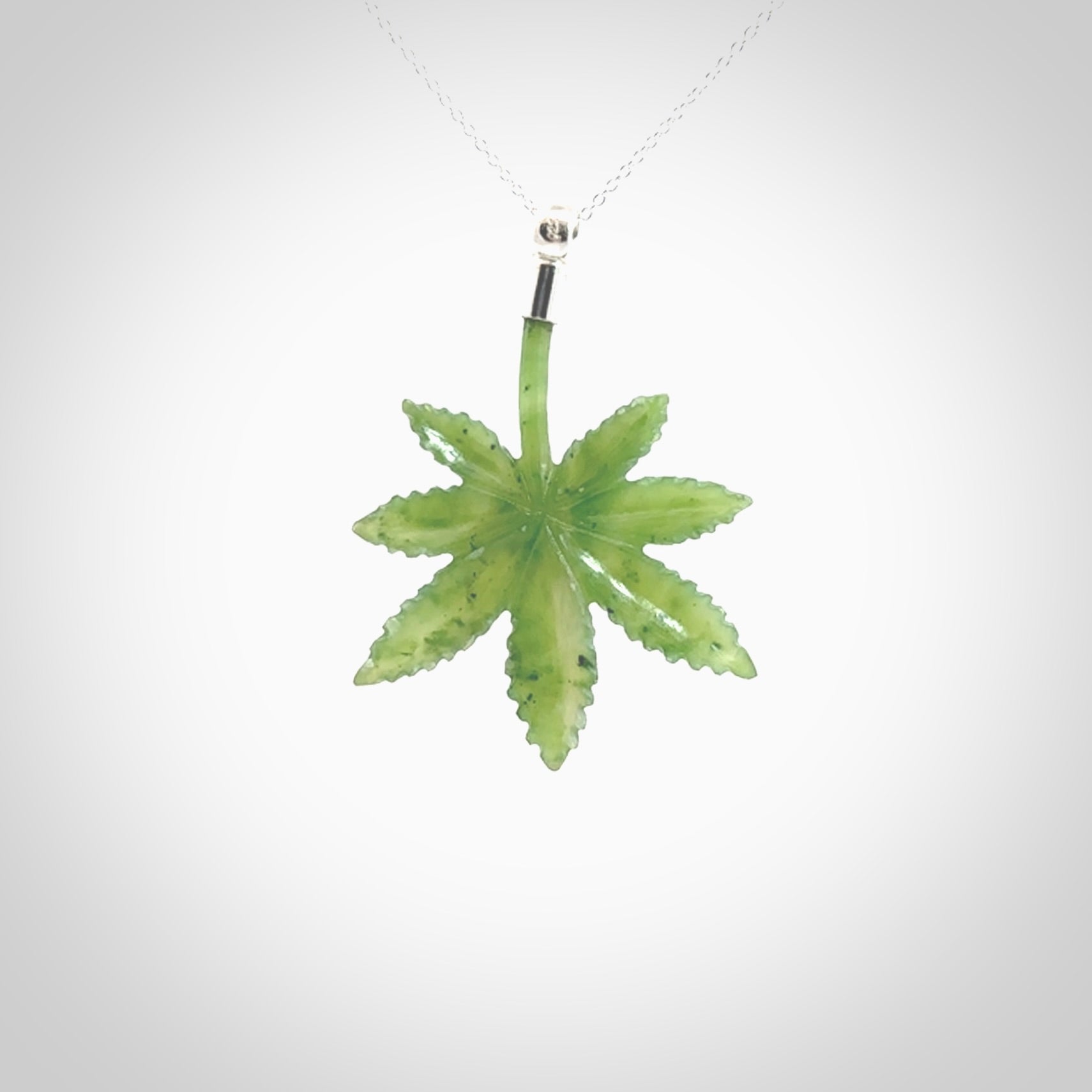 Cannabis Leaf Jade pendant with Sterling Silver Cap. Handmade jade Cannabis leaf jewellery made by NZ Pacific and for sale online. Jade Marijuana leaf pendant for men and women. Unique art to wear from NZ Pacific. Delivered on a Sterling Silver Chain.