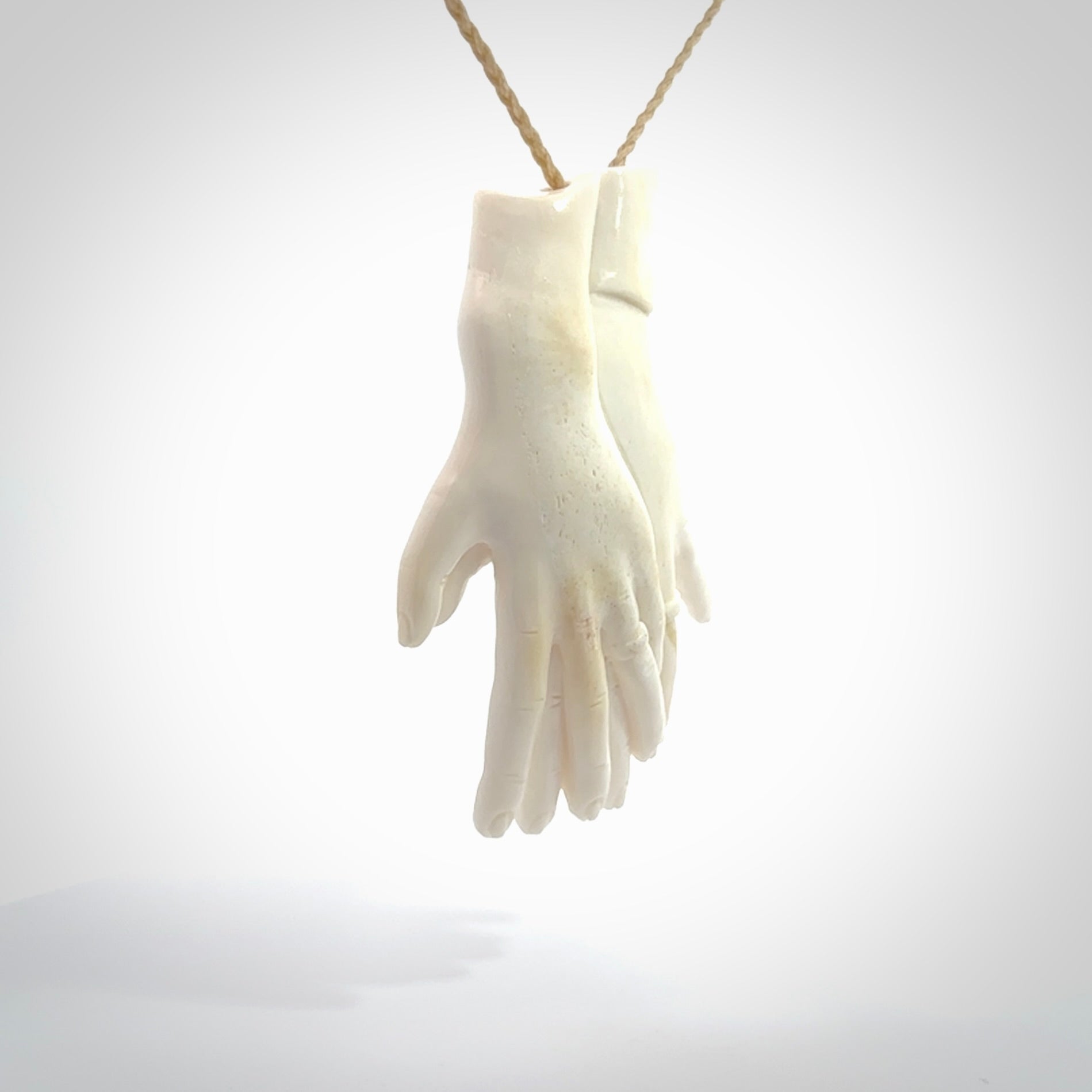 Hand carved large bone double hands with wedding rings pendant. A stunning work of art. This pendant is hand carved in bone and provided with an adjustable cord. A one off work of art to wear by NZ Pacific.