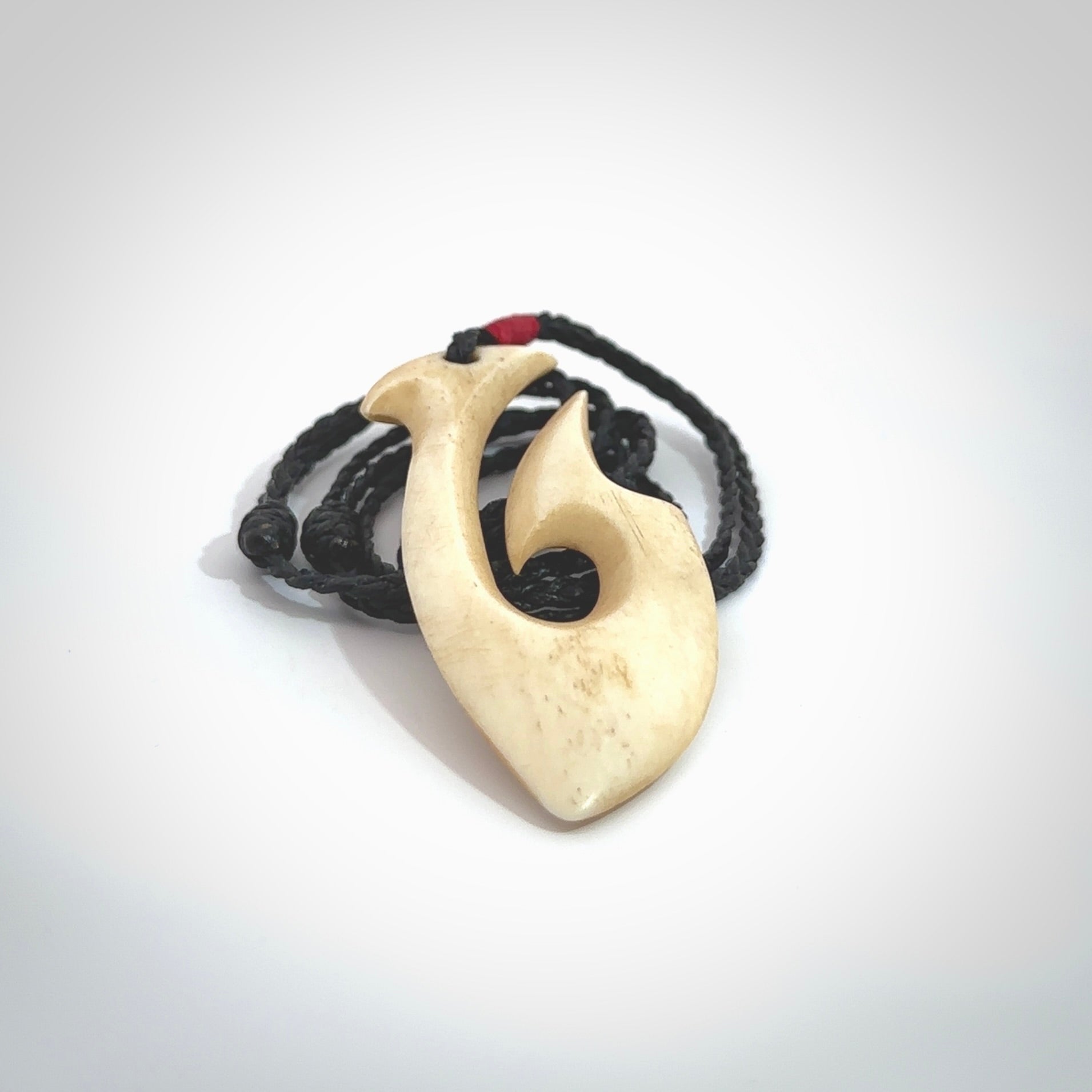 This is a larger bone hook, or matau, pendant carved from a piece of bone. The cord is your choice of a black or burgundy colour and the length of the cord can be adjusted. It is a large sized pendant and is well carved. A beautiful piece of traditional jewellery. Hand made by Yuri Terenyi.