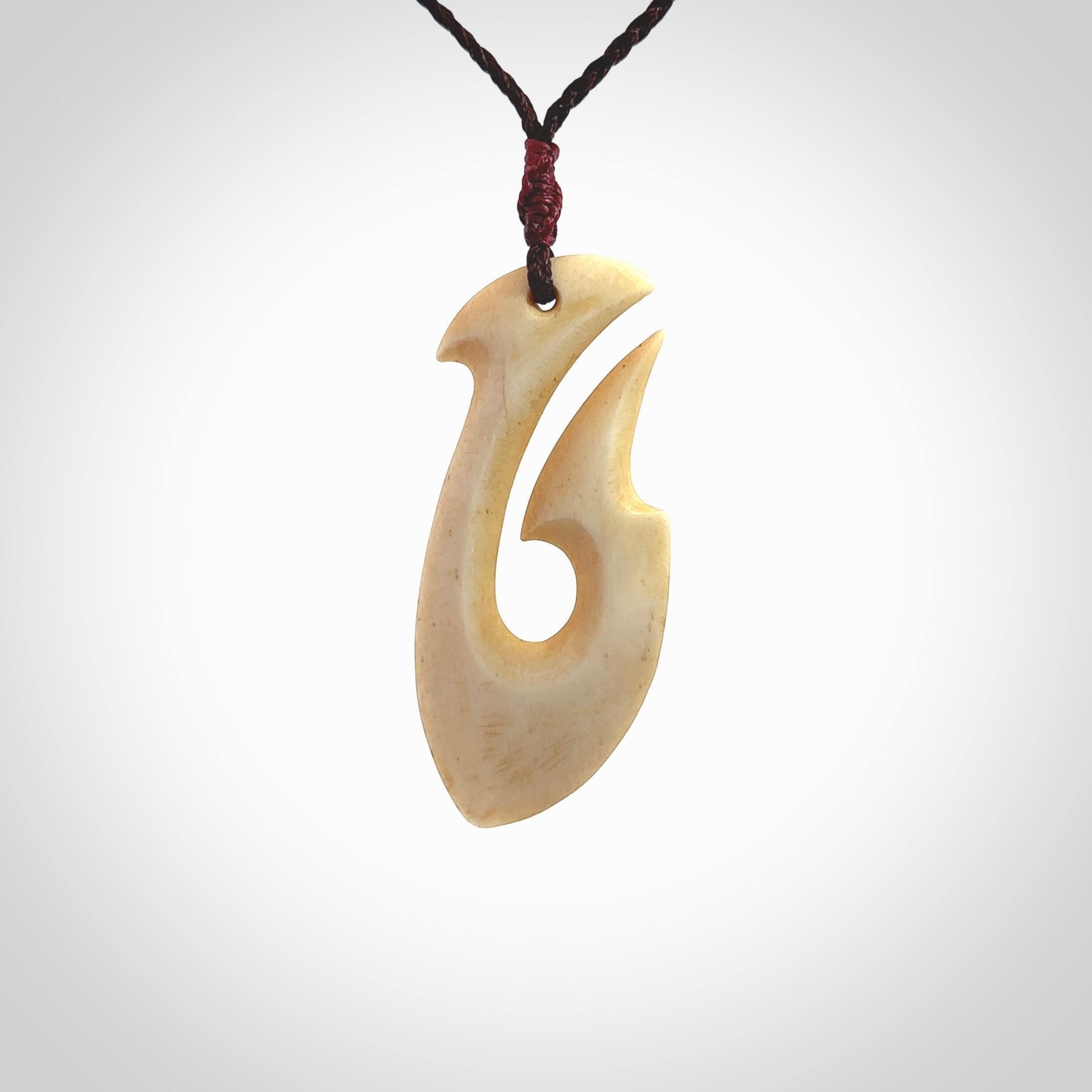 This is a larger bone hook, or matau, pendant carved from a piece of bone. The cord is your choice of a black or burgundy colour and the length of the cord can be adjusted. It is a large sized pendant and is well carved. A beautiful piece of traditional jewellery. Hand made by Yuri Terenyi.