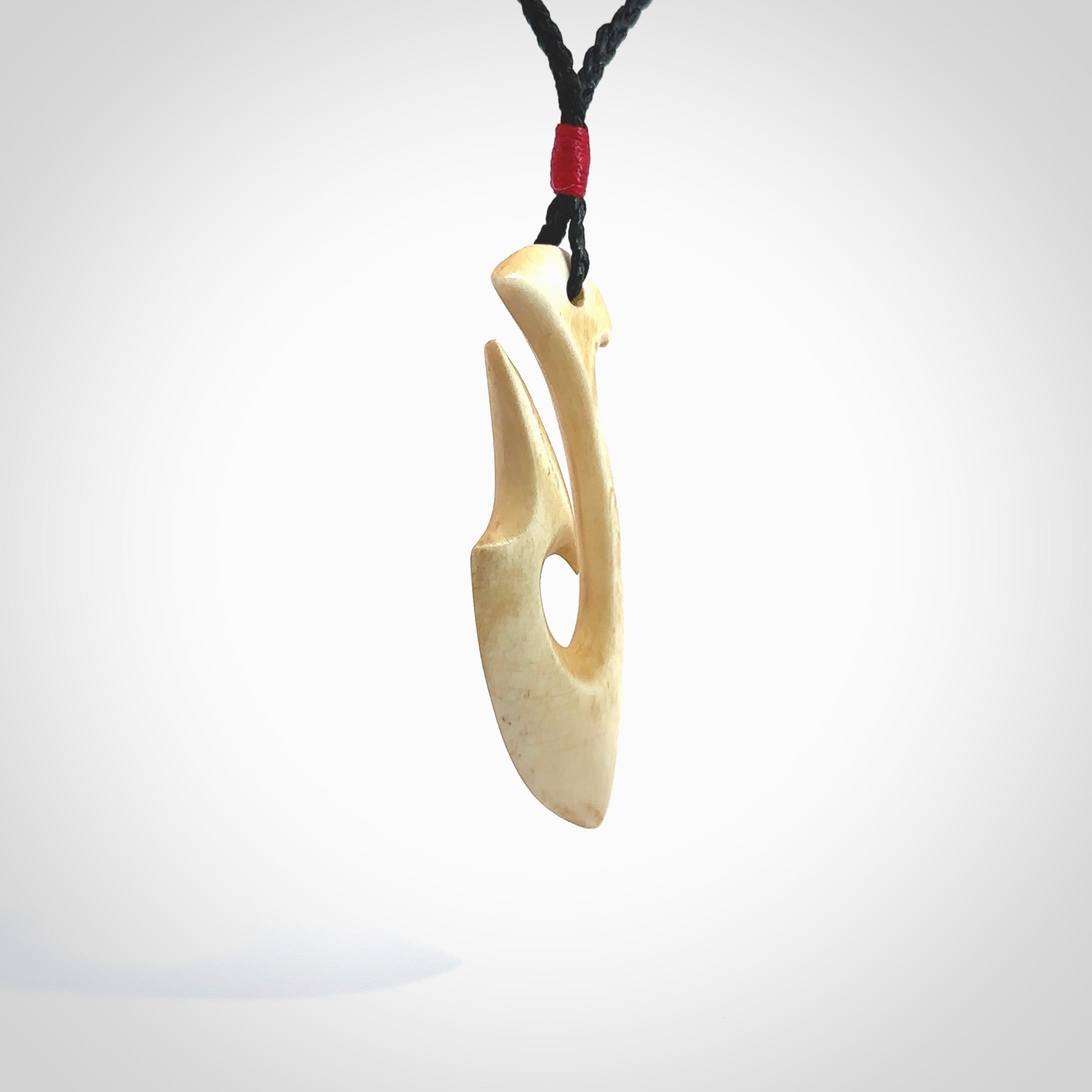 This is a larger bone hook, or matau, pendant carved from a piece of bone. The cord is your choice of a black or burgundy colour and the length of the cord can be adjusted. It is a large sized pendant and is well carved. A beautiful piece of traditional jewellery. Hand made by Yuri Terenyi.