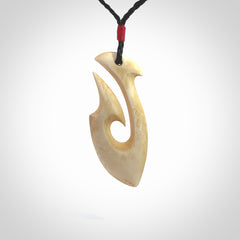 This is a larger bone hook, or matau, pendant carved from a piece of bone. The cord is your choice of a black or burgundy colour and the length of the cord can be adjusted. It is a large sized pendant and is well carved. A beautiful piece of traditional jewellery. Hand made by Yuri Terenyi.