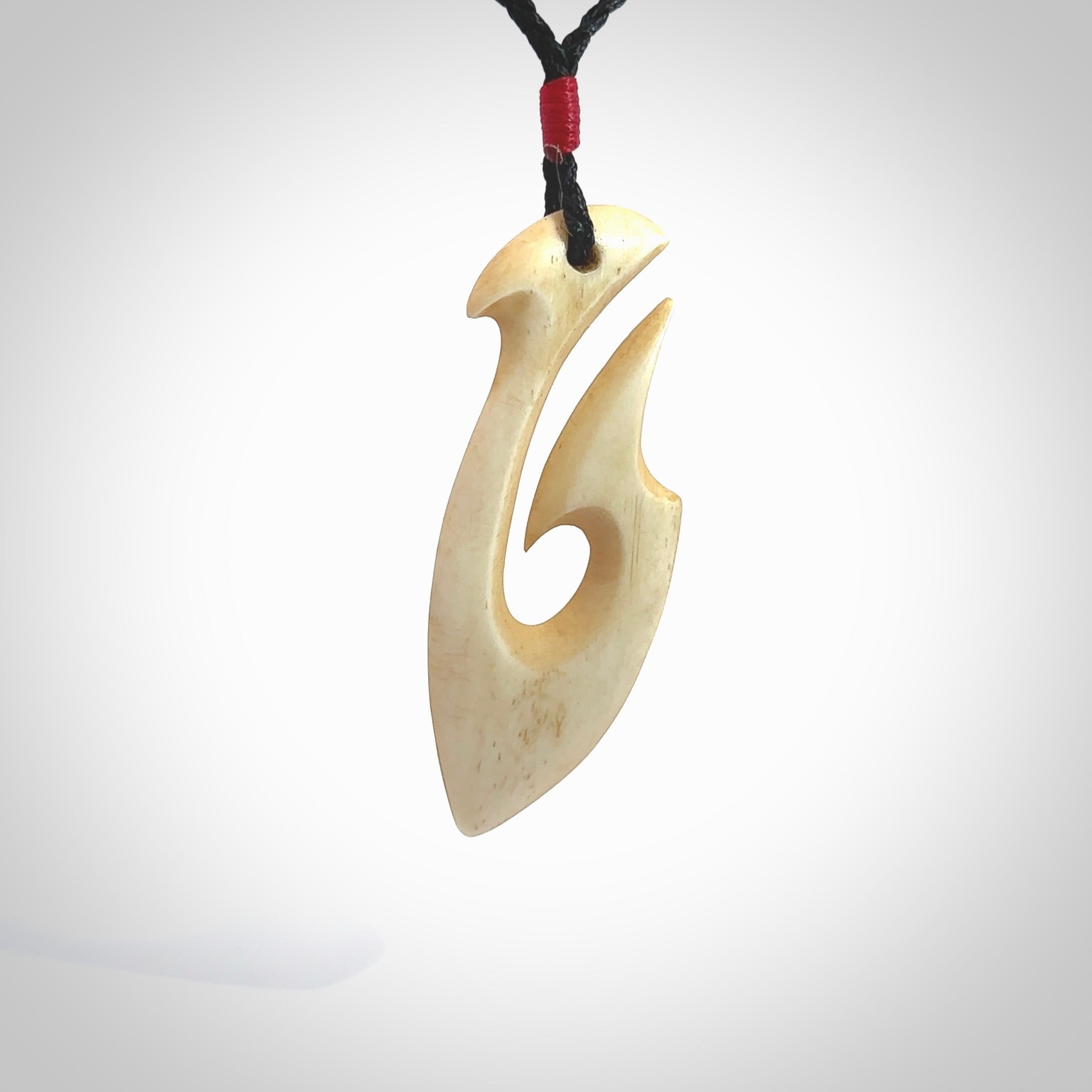 This is a larger bone hook, or matau, pendant carved from a piece of bone. The cord is your choice of a black or burgundy colour and the length of the cord can be adjusted. It is a large sized pendant and is well carved. A beautiful piece of traditional jewellery. Hand made by Yuri Terenyi.