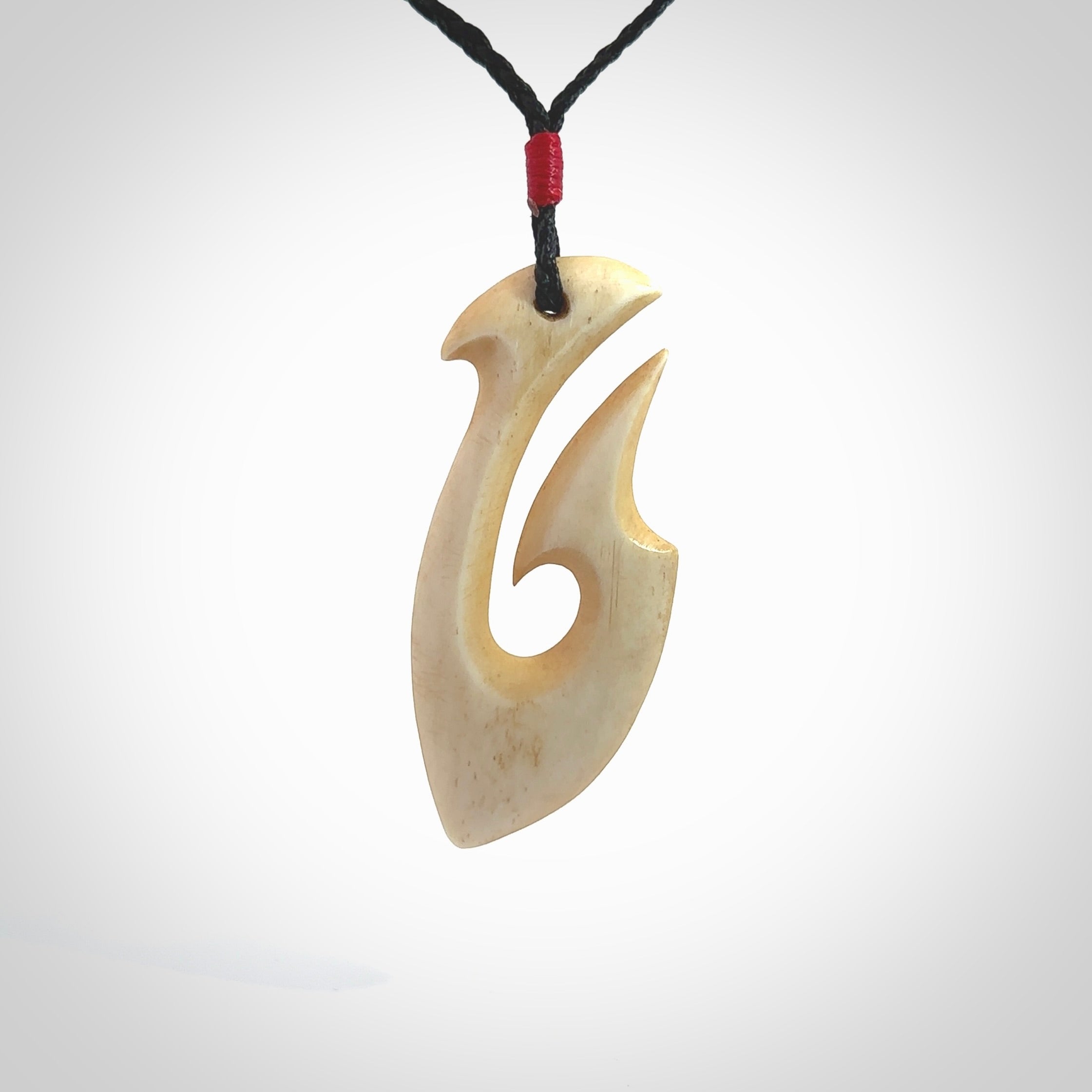 This is a larger bone hook, or matau, pendant carved from a piece of bone. The cord is your choice of a black or burgundy colour and the length of the cord can be adjusted. It is a large sized pendant and is well carved. A beautiful piece of traditional jewellery. Hand made by Yuri Terenyi.