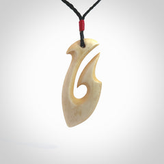 This is a larger bone hook, or matau, pendant carved from a piece of bone. The cord is your choice of a black or burgundy colour and the length of the cord can be adjusted. It is a large sized pendant and is well carved. A beautiful piece of traditional jewellery. Hand made by Yuri Terenyi.