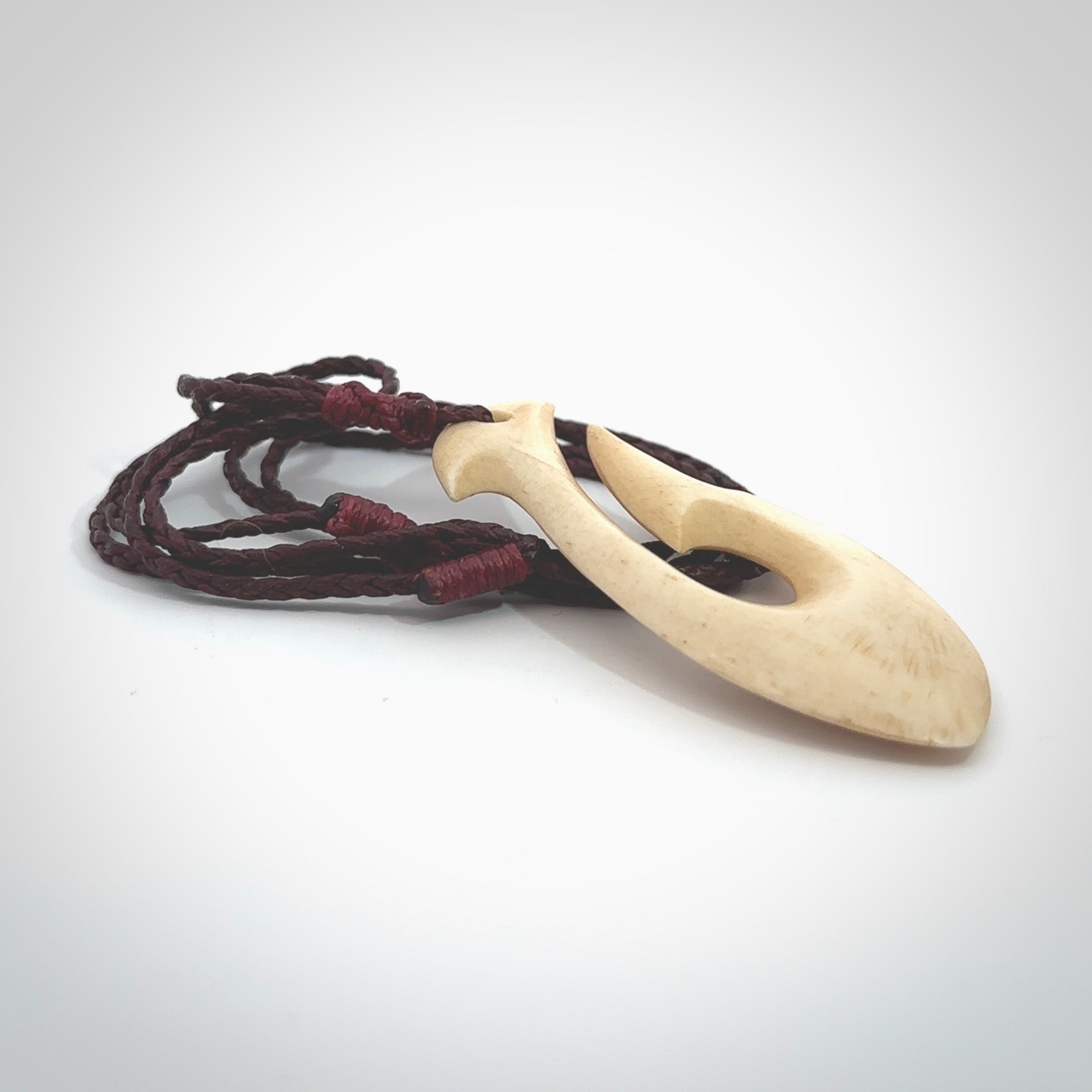 This is a larger bone hook, or matau, pendant carved from a piece of bone. The cord is your choice of a black or burgundy colour and the length of the cord can be adjusted. It is a large sized pendant and is well carved. A beautiful piece of traditional jewellery. Hand made by Yuri Terenyi.