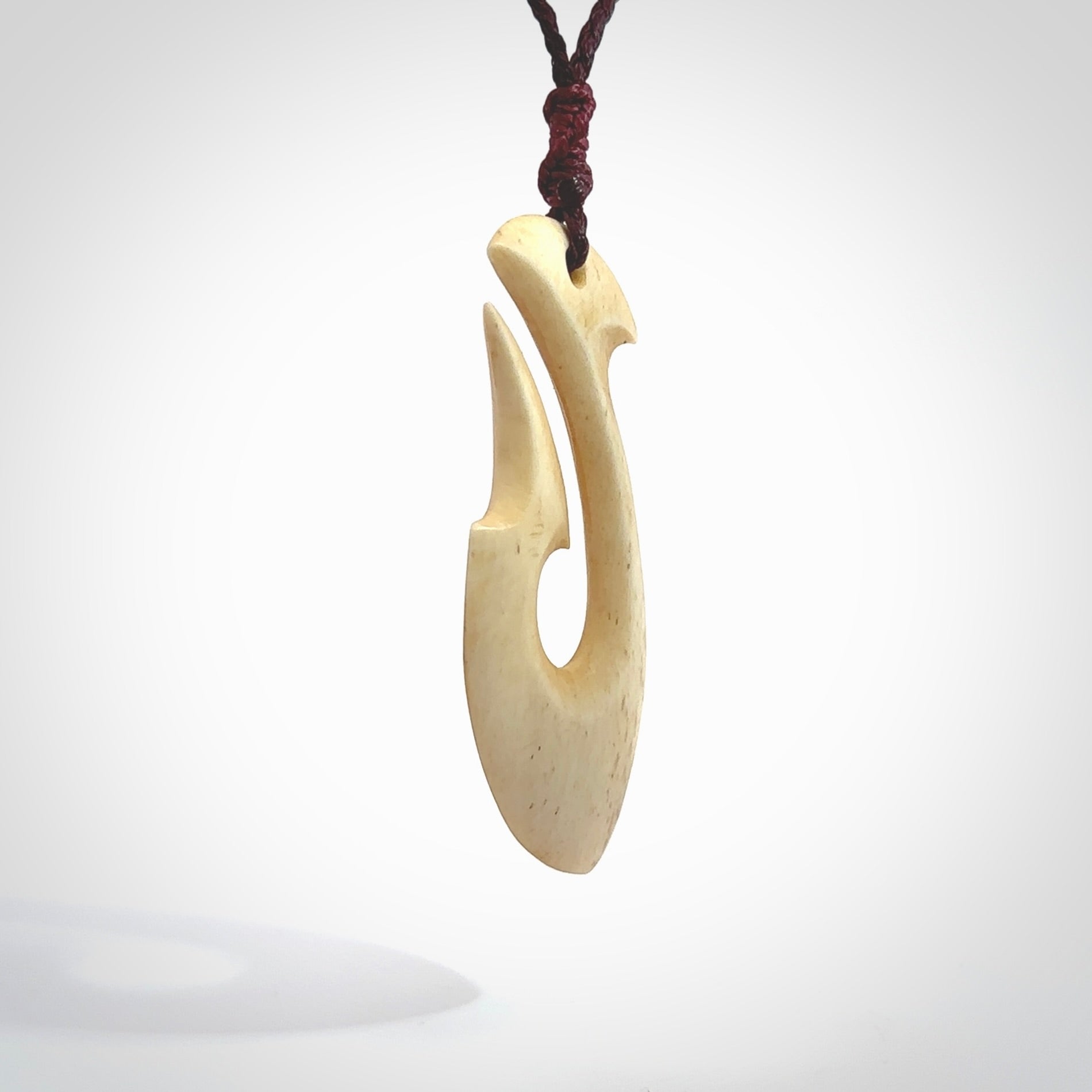 This is a larger bone hook, or matau, pendant carved from a piece of bone. The cord is your choice of a black or burgundy colour and the length of the cord can be adjusted. It is a large sized pendant and is well carved. A beautiful piece of traditional jewellery. Hand made by Yuri Terenyi.