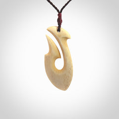 This is a larger bone hook, or matau, pendant carved from a piece of bone. The cord is your choice of a black or burgundy colour and the length of the cord can be adjusted. It is a large sized pendant and is well carved. A beautiful piece of traditional jewellery. Hand made by Yuri Terenyi.