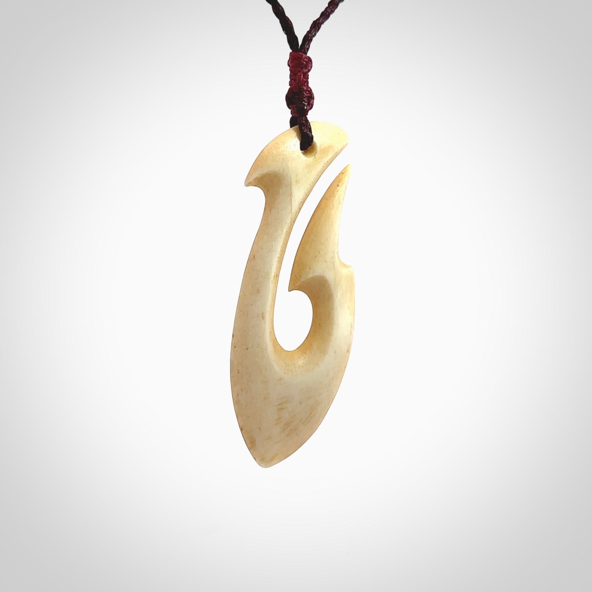 This is a larger bone hook, or matau, pendant carved from a piece of bone. The cord is your choice of a black or burgundy colour and the length of the cord can be adjusted. It is a large sized pendant and is well carved. A beautiful piece of traditional jewellery. Hand made by Yuri Terenyi.