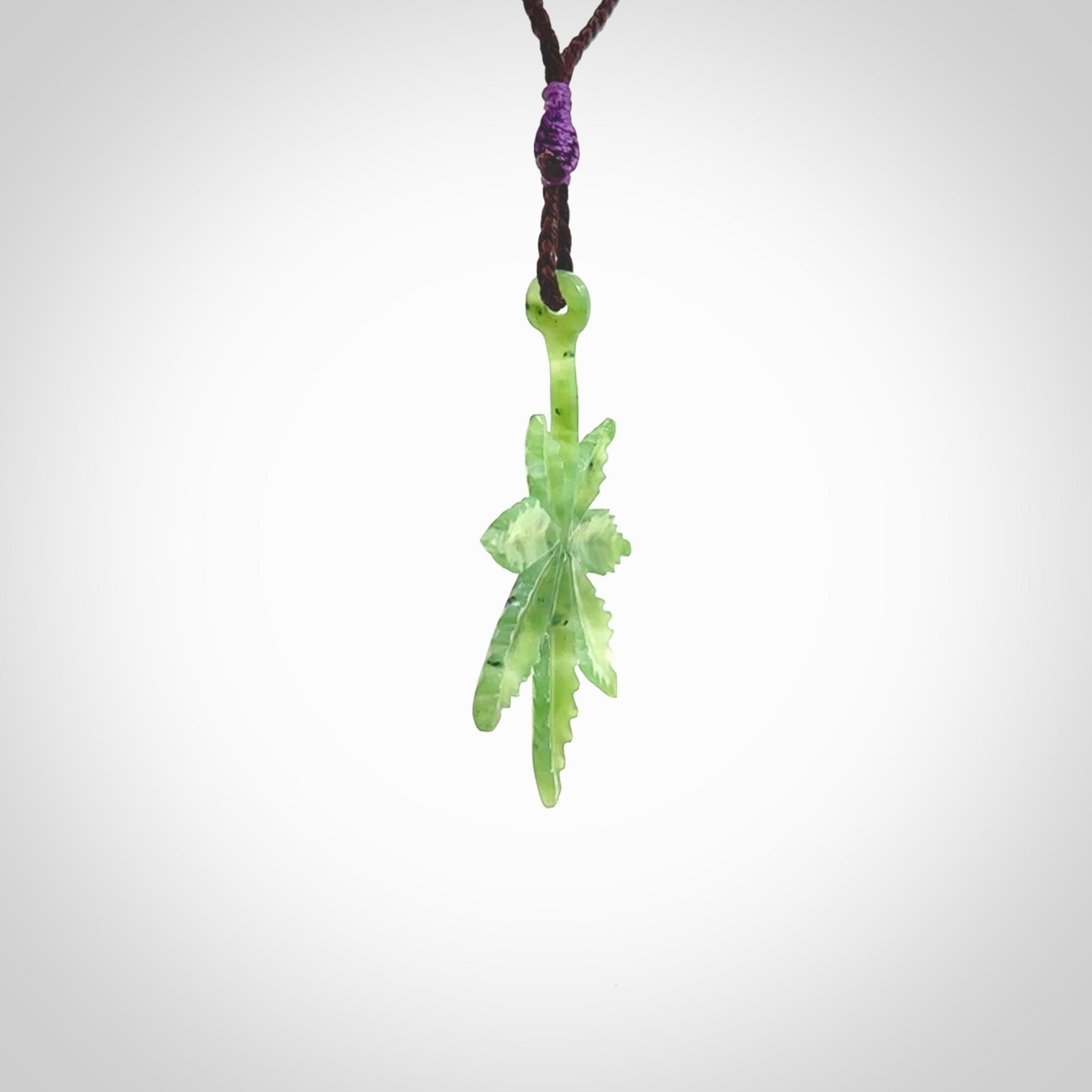 Cannabis Leaf Jade Stone pendant. Handmade jade Cannabis flower jewellery made by NZ Pacific and for sale online. Jade stone Marijuana leaf pendant for men and women. Unique art to wear from NZ Pacific. Delivered on an adjustable Plum cord.