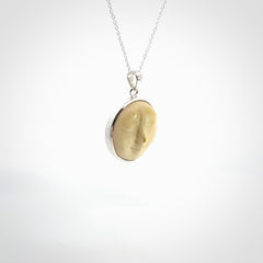 Hand made woolly mammoth tusk moon face necklace. Made by NZ Pacific and sale online only. Delivered with sterling silver chain and packaged in a woven kete pouch.