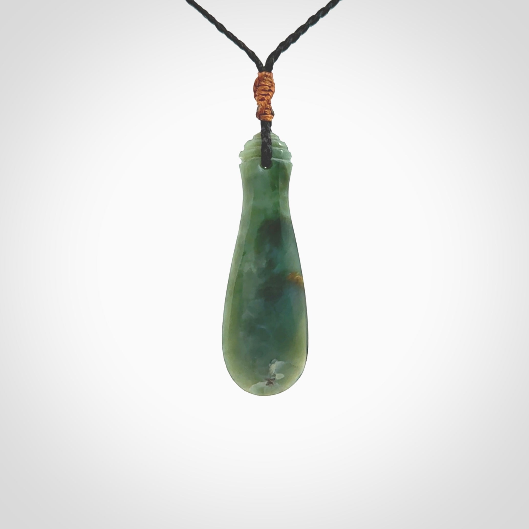 This is a sleek and slender hand carved New Zealand Jade mere pendant. The stone is a very beautiful green and the cord is either black or green and is adjustable. The pendant has a light polish and just glows. Provided in a woven kete pouch.