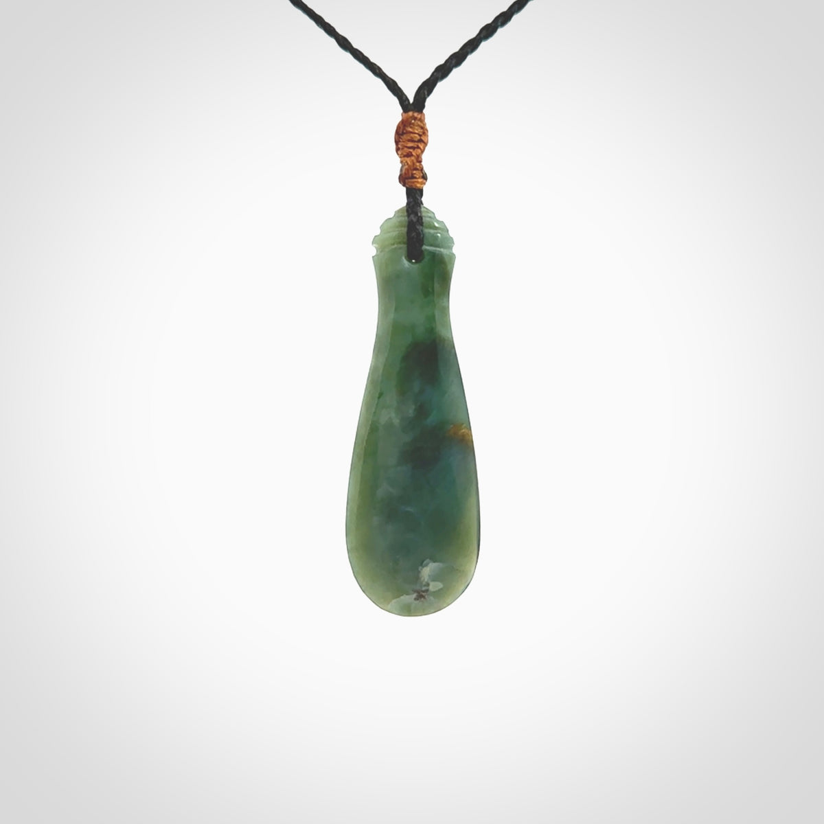 This is a sleek and slender hand carved New Zealand Jade mere pendant. The stone is a very beautiful green and the cord is either black or green and is adjustable. The pendant has a light polish and just glows. Provided in a woven kete pouch.