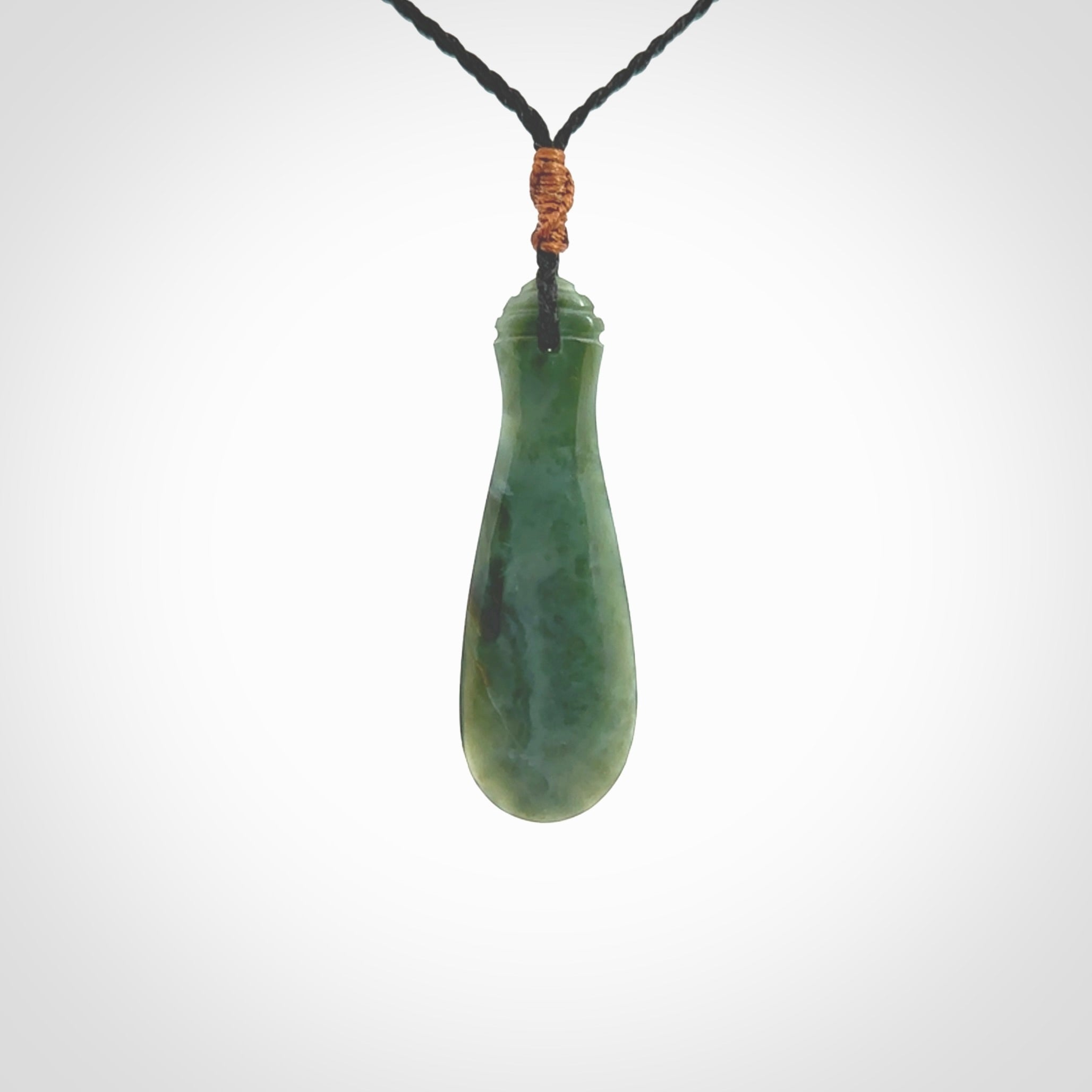 This is a sleek and slender hand carved New Zealand Jade mere pendant. The stone is a very beautiful green and the cord is either black or green and is adjustable. The pendant has a light polish and just glows. Provided in a woven kete pouch.