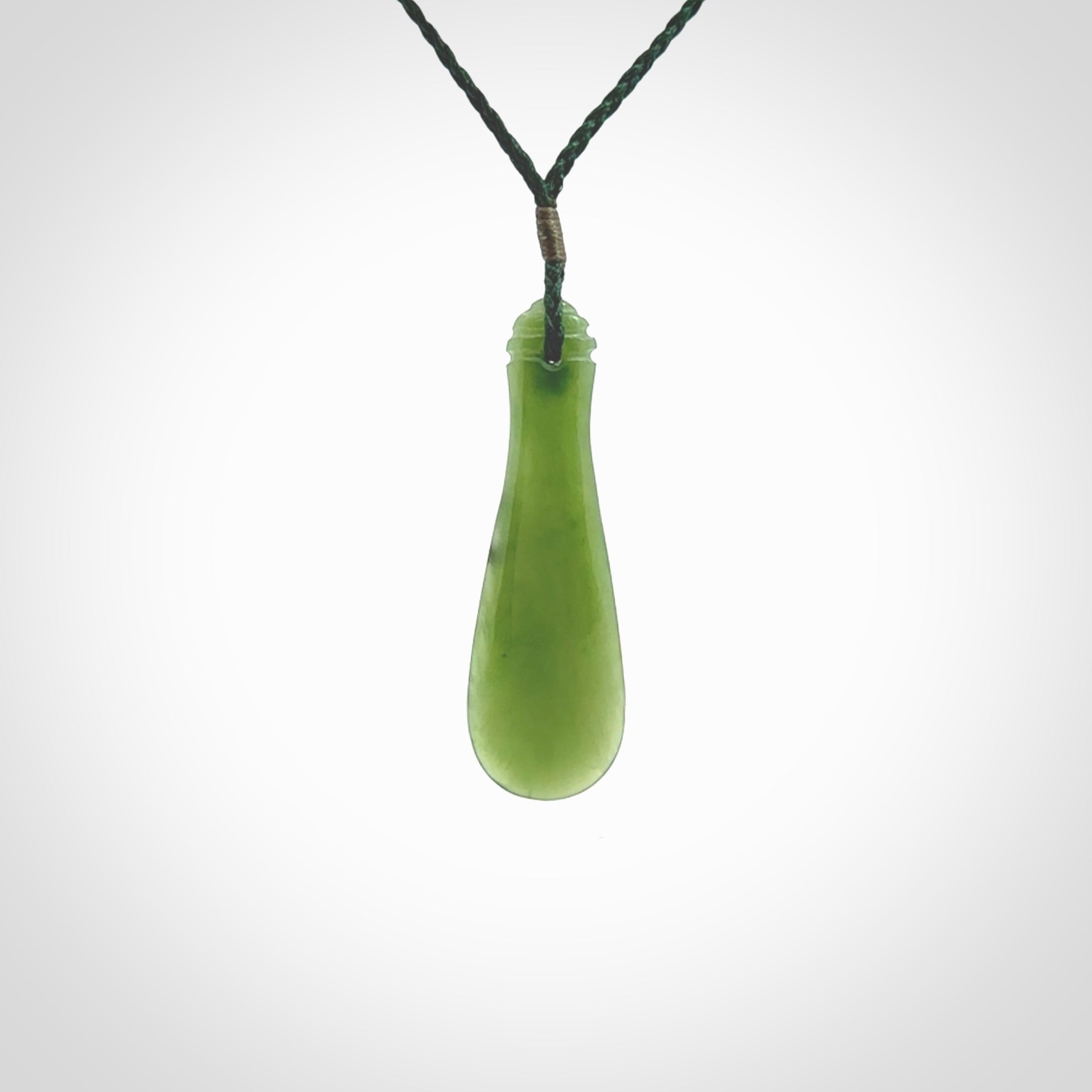 This is a sleek and slender hand carved New Zealand Jade mere pendant. The stone is a very beautiful green and the cord is either black or green and is adjustable. The pendant has a light polish and just glows. Provided in a woven kete pouch.