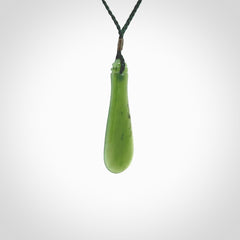 This is a sleek and slender hand carved New Zealand Jade mere pendant. The stone is a very beautiful green and the cord is either black or green and is adjustable. The pendant has a light polish and just glows. Provided in a woven kete pouch.