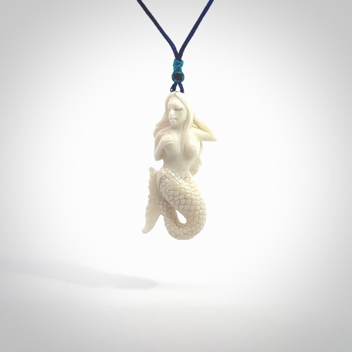 Hand carved natural bone mermaid pendant. Hand made from real bone. Art to wear. Provided with adjustable cord and packaged in a woven kete pouch.