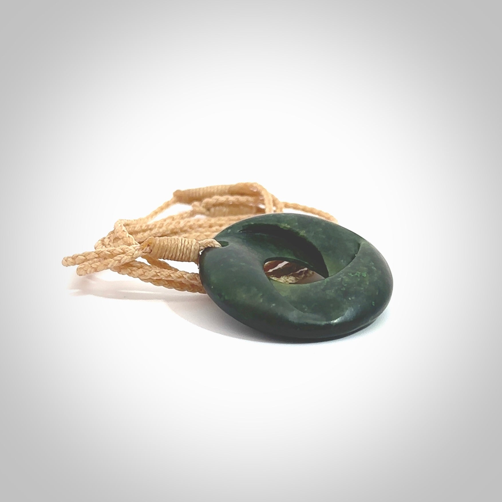 This small sized piece is a hand carved möbius ribbon pendant. Kyohei Noguchi has carved this from New Zealand Nephrite Jade. It has very subtle colour variations in the stone and is a delightful, small and artistic piece of jewellery. Delivered with an adjustable beige cord.