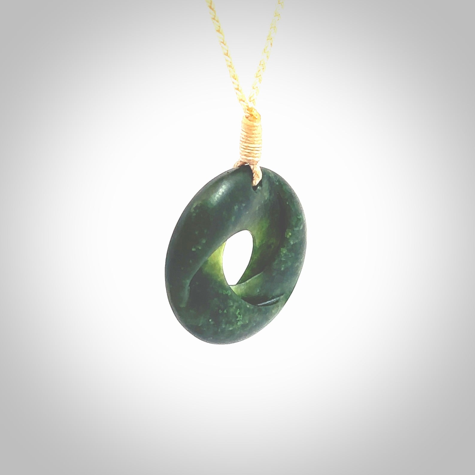 This small sized piece is a hand carved möbius ribbon pendant. Kyohei Noguchi has carved this from New Zealand Nephrite Jade. It has very subtle colour variations in the stone and is a delightful, small and artistic piece of jewellery. Delivered with an adjustable beige cord.