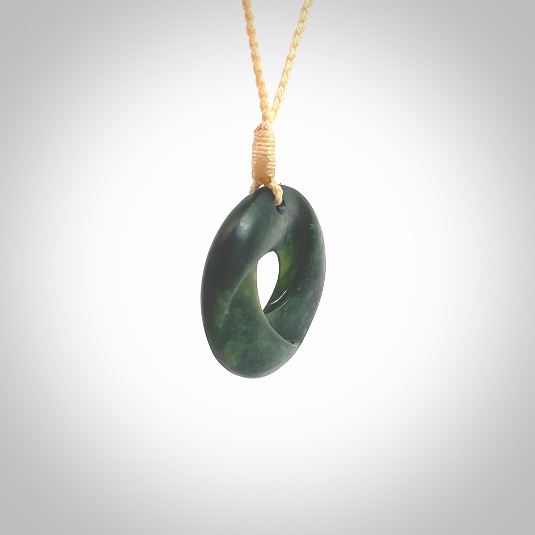 This small sized piece is a hand carved möbius ribbon pendant. Kyohei Noguchi has carved this from New Zealand Nephrite Jade. It has very subtle colour variations in the stone and is a delightful, small and artistic piece of jewellery. Delivered with an adjustable beige cord.