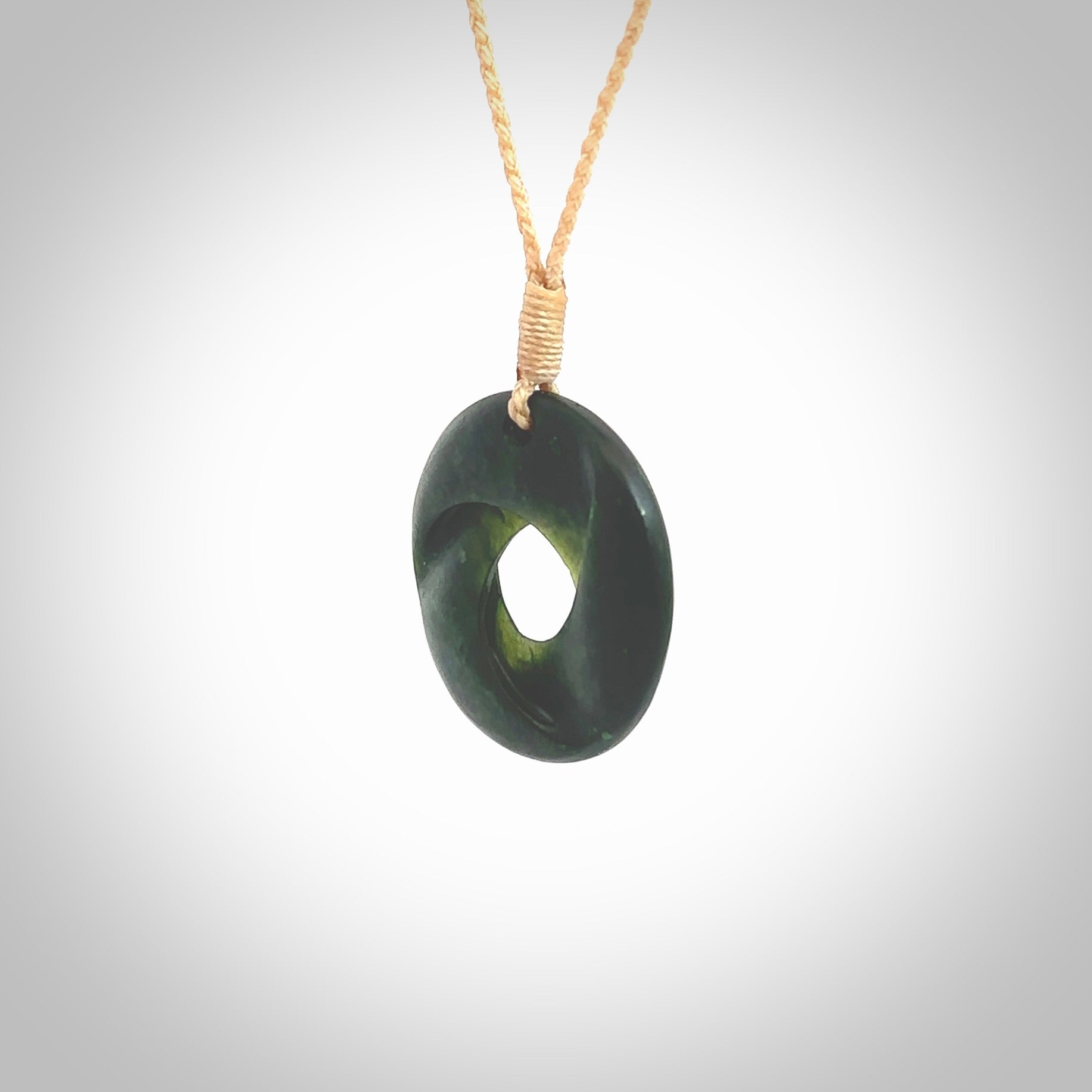 This small sized piece is a hand carved möbius ribbon pendant. Kyohei Noguchi has carved this from New Zealand Nephrite Jade. It has very subtle colour variations in the stone and is a delightful, small and artistic piece of jewellery. Delivered with an adjustable beige cord.