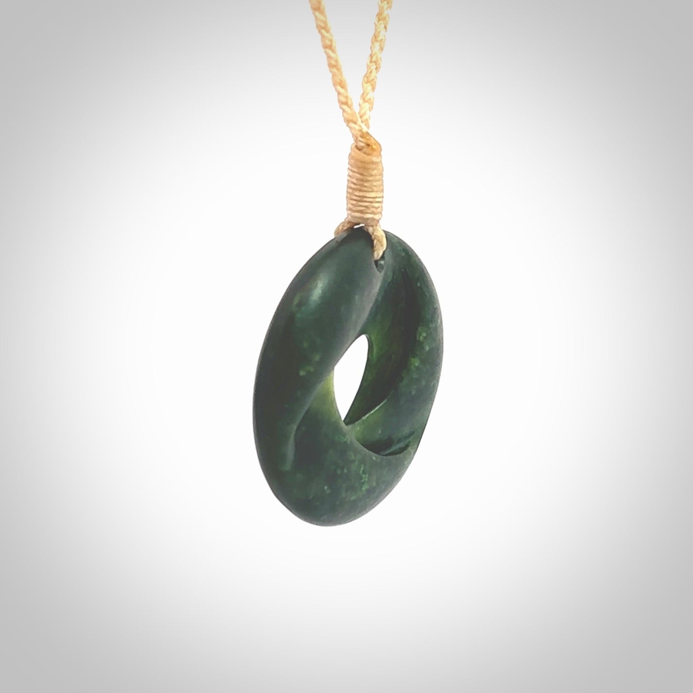 This small sized piece is a hand carved möbius ribbon pendant. Kyohei Noguchi has carved this from New Zealand Nephrite Jade. It has very subtle colour variations in the stone and is a delightful, small and artistic piece of jewellery. Delivered with an adjustable beige cord.