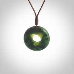 This little piece is a hand carved möbius ribbon pendant. We've carved this from New Zealand Jade. It has very subtle colour variations in the stone and is a delightful, small and artistic piece of jewellery. Hand made by Kyohei Noguchi and delivered to you in a kete pouch. Delivered to you on an adjustable brown cord.