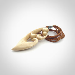 A hand carved masterpiece. A beautiful contemporary pendant carved from bone by Yuri Terenyi for NZ Pacific. This is a true piece of wearable art which is collectible. A one-off pendant representing a mother and child. Provided with an adjustable gingernut cord and packaged in a woven kete pouch.