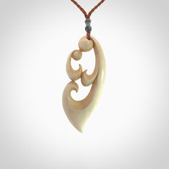 A hand carved masterpiece. A beautiful contemporary pendant carved from bone by Yuri Terenyi for NZ Pacific. This is a true piece of wearable art which is collectible. A one-off pendant representing a mother and child. Provided with an adjustable gingernut cord and packaged in a woven kete pouch.