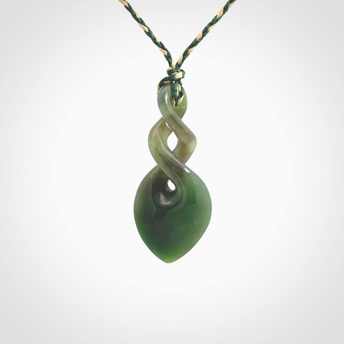 Hand carved New Zealand jade twist pendant. Carved in New Zealand by NZ Pacific. Unique double twist jewellery for sale online. Provided with an adjustable manuka green/kalahari cord.