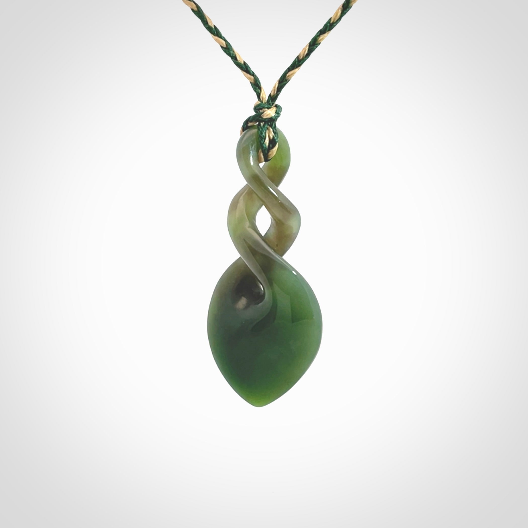 Hand carved New Zealand jade twist pendant. Carved in New Zealand by NZ Pacific. Unique double twist jewellery for sale online. Provided with an adjustable manuka green/kalahari cord.