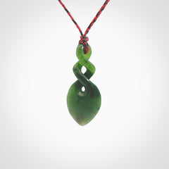 Hand carved New Zealand jade twist pendant. Carved in New Zealand by NZ Pacific. Unique double twist jewellery for sale online. Provided with an adjustable red/black cord.