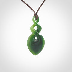 Hand carved New Zealand jade twist pendant. Carved in New Zealand by NZ Pacific. Unique double twist jewellery for sale online. Provided with an adjustable chocolate brown cord.